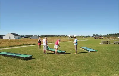 a group of people playing with trampoline in a field at Holiday Home Kronvildtvej Brovst I in Brovst