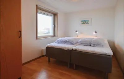 a bedroom with a bed with two pillows on it at Holiday Home Sandnæshagevej Frøstrup Iv in Frøstrup