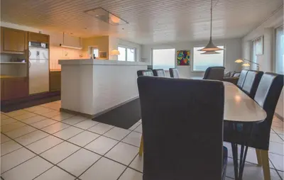 a kitchen and dining room with a table and chairs at Holiday Home Sandnæshagevej Frøstrup Iv in Frøstrup
