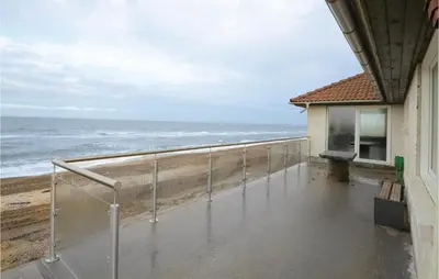 a balcony with a view of the ocean at Holiday Home Sandnæshagevej Frøstrup Iv in Frøstrup
