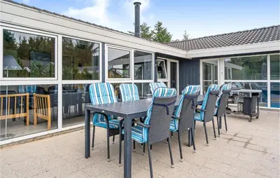 a table and chairs on a patio with a grill at 4 Bedroom Stunning Home In Fjerritslev in Fjerritslev
