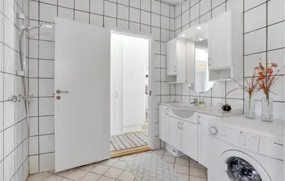 a white bathroom with a sink and a washing machine at Holiday Home Hermodsvej Harboøre Xi in Harboør