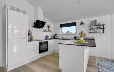 a kitchen with white cabinets and a black counter top at Holiday Home Hermodsvej Harboøre Xi in Harboør