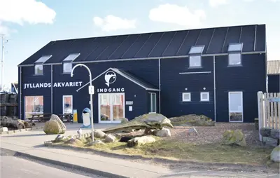 a blue building with a sign in front of it at Holiday Home Gloryvej Harboøre Iv in Harboør