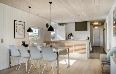 a kitchen and dining room with a table and chairs at Holiday Home Vejlby Klit Harboøre V in Harboør