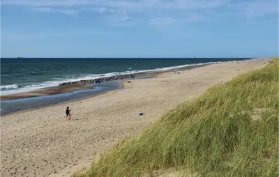 a person standing on a beach next to the ocean at Gorgeous Home In Harboøre With Sauna in Harboør