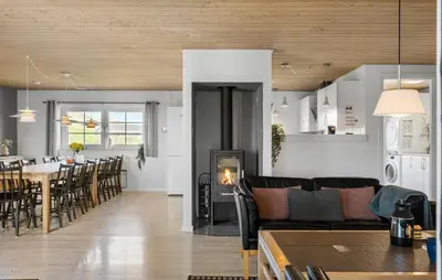 a living room with a couch and a table with a fireplace at Gorgeous Home In Harboøre With Sauna in Harboør