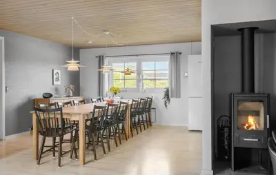 a dining room with a table and chairs and a fireplace at Gorgeous Home In Harboøre With Sauna in Harboør