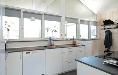 a white kitchen with white cabinets and windows at Amazing Home In Saltum With Wifi in Saltum