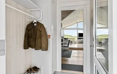 a hallway with a jacket hanging on a wall at Holiday Home Monasvej Løkken Iv in Løkken