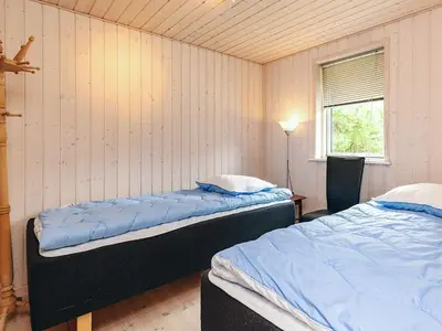 two beds sitting in a room with a window at 6 person holiday home in Løgstør in Løgsted