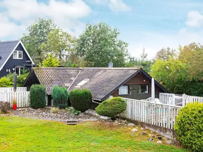 a house with a white fence in front of a yard at 8 person holiday home in Løgstør-By Traum in Løgstør