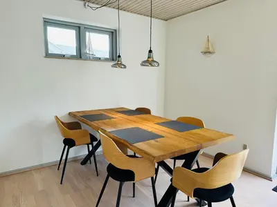 a wooden table and chairs in a room at Beautiful villa close to beach and nature in Hanstholm