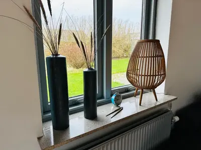 three vases sitting on a window sill with a bird at Beautiful villa close to beach and nature in Hanstholm