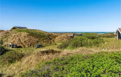 a house on top of a grassy hill at Holiday Home Monasvej Xii in Løkken