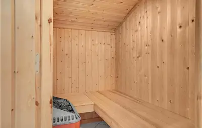 a wooden sauna with a bench in the corner at Holiday Home Monasvej Xii in Løkken