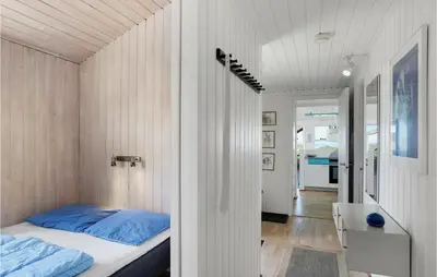 a small bedroom with a bed and a table at Pynten in Løkken