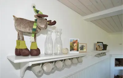 a shelf with glass vases and a stuffed animal on it at Holiday Home Rødhus Klitvej in Pandrup