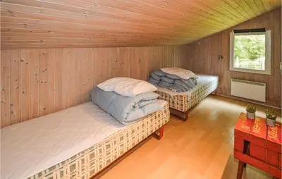 two beds in a room with wooden walls at Stunning Home In Saltum With Sauna in Saltum
