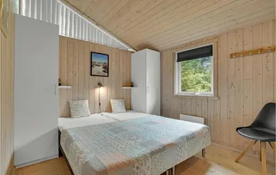 a bedroom with a bed and a window at Holiday Home Jægerens Vej in Blokhus