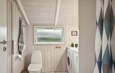 a small bathroom with a toilet and a window at Holiday Home Kristavej Løkken Xii in Løkken