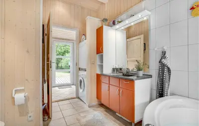 a bathroom with a sink and a washing machine at Holiday Home Stellavej Løkken Denm in Løkken