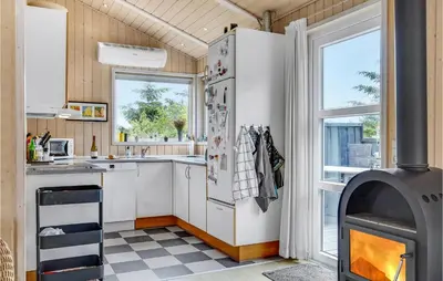 a kitchen with a stove in a tiny house at Holiday Home Stellavej Løkken Denm in Løkken