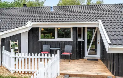 a black house with a white fence and a deck at Lovely Home In Saltum With Kitchen in Saltum