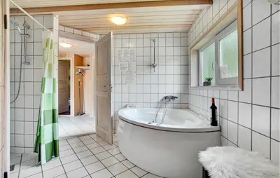 a bathroom with a tub and a walk in shower at Lovely Home In Saltum With Kitchen in Saltum