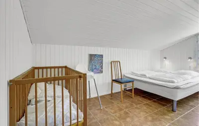 a bedroom with a bunk bed and a chair at Awesome Home In Blokhus With Wifi in Blokhus