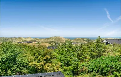 a view of trees and the ocean from a house at Holiday Home Lyngvej Blokhus Iv in Blokhus