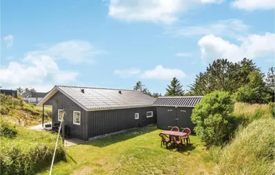 a house with a picnic table in the yard at Holiday Home Kristinesvej Blokhus X in Blokhus