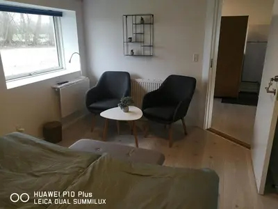 a living room with two chairs and a table at Landevejens B&B Holstebro in Holstebro