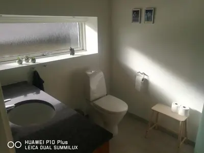 a bathroom with a toilet and a sink and a window at Landevejens B&B Holstebro in Holstebro