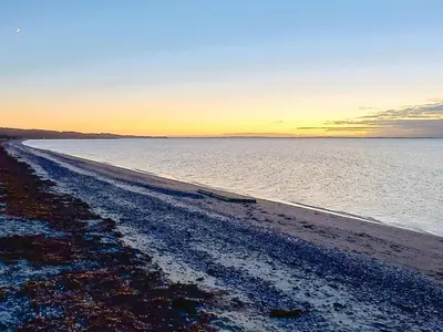 a beach with the sun setting over the water at 8 person holiday home in Løgstør-By Traum in Løgsted