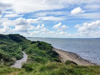 a view of a beach and the ocean on a cloudy day at 6 person holiday home in Løgstør-By Traum in Løgsted