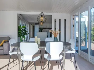 a dining room with a table and white chairs at 6 person holiday home in Løgstør-By Traum in Løgsted
