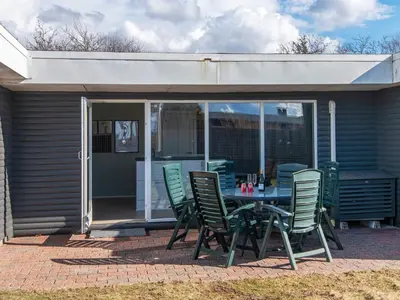 a patio with a table and chairs in front of a house at 6 person holiday home in Løgstør-By Traum in Løgsted