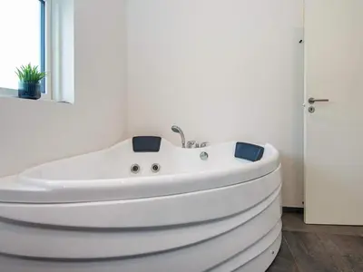 a white bath tub in a bathroom with a window at 6 person holiday home in Lemvig-By Traum in Lemvig