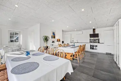 a kitchen and dining room with white tables and chairs at Lildgaard in Frøstrup
