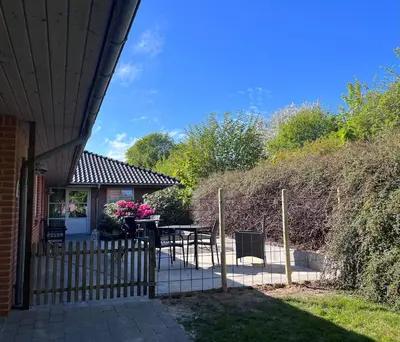 a house with a fence and a table and chairs at Kørestolsvenligt dbl. vær. in Nykøbing Mors