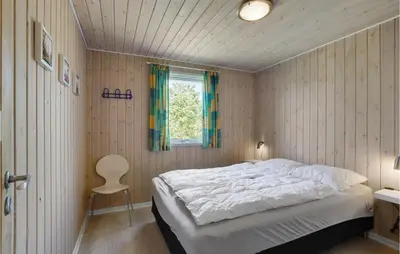 a bedroom with a bed and a window and a chair at Awesome Home In Løgstør With Sauna in Løgstør
