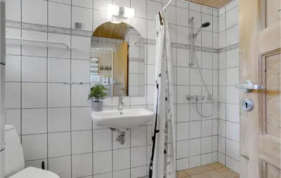 a white bathroom with a sink and a mirror at Awesome Home In Løgstør With Sauna in Løgstør