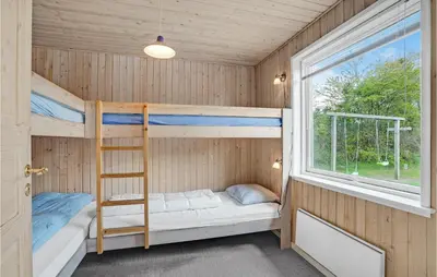 a bunk bed in a room with a window at Holiday Home Illeris Xi in Farsø