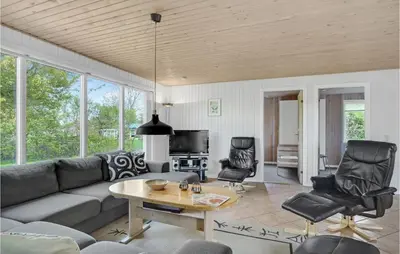 a living room with a couch and a table and chairs at Holiday Home Illeris Xi in Farsø