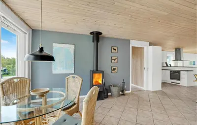 a dining room with a glass table and a fireplace at Holiday Home Illeris Xi in Farsø