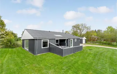 a small grey house on a green lawn at Holiday Home Illeris Xi in Farsø