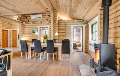 a dining room with a fireplace and a table and chairs at Holiday Home Ramshule Farsø Xii in Farsø