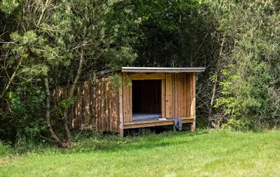 a wooden out house in the middle of a field at Holiday Home Kjeldhøj Farsø Xi in Farsø