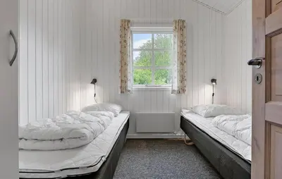 two beds in a room with a window at Holiday Home Kjeldhøj Farsø Xi in Farsø